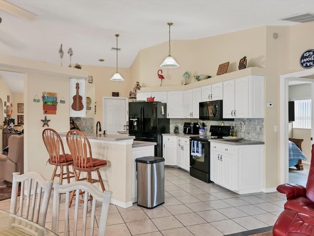 kitchen with kitchen peninsula, black appliances, light tile patterned floors, decorative light fixtures, and white cabinetry