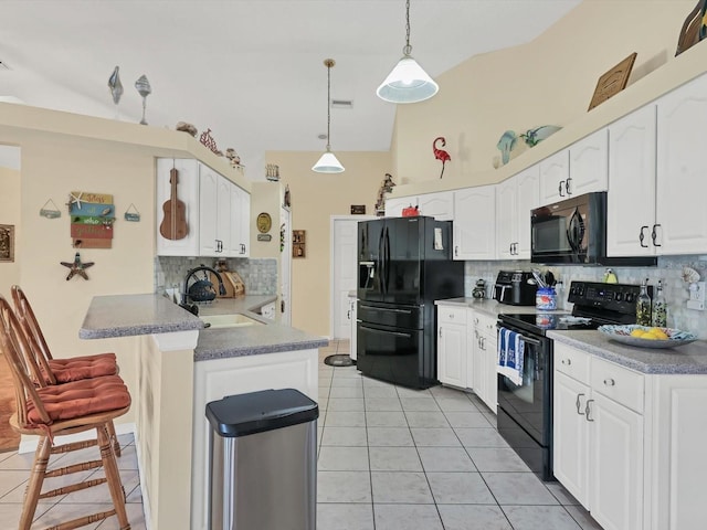 kitchen with black appliances, decorative light fixtures, and white cabinets