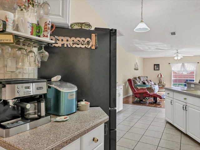 kitchen featuring ceiling fan, white cabinets, pendant lighting, and light tile patterned floors