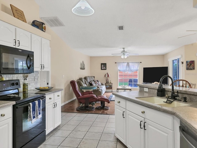 kitchen with black appliances, white cabinets, light tile patterned floors, and sink