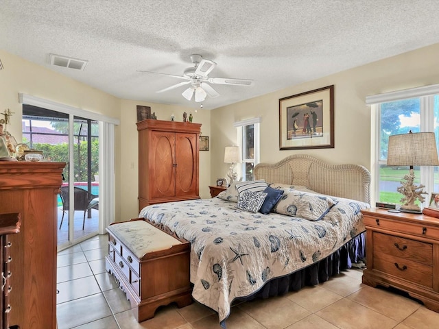 bedroom featuring access to exterior, a textured ceiling, ceiling fan, and light tile patterned flooring