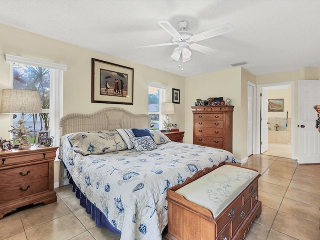 tiled bedroom with a textured ceiling, connected bathroom, and ceiling fan