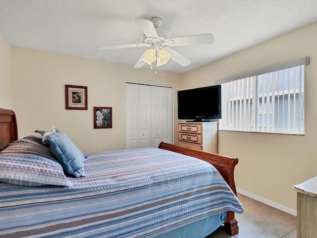 bedroom featuring light tile patterned floors, a textured ceiling, a closet, and ceiling fan