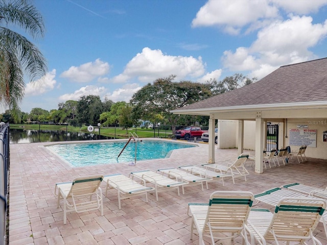 view of pool with a patio area and a water view