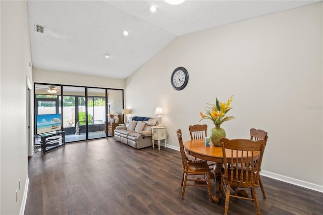 dining space with a textured ceiling, lofted ceiling, and dark hardwood / wood-style floors