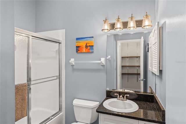 full bathroom featuring vanity, toilet, and bath / shower combo with glass door