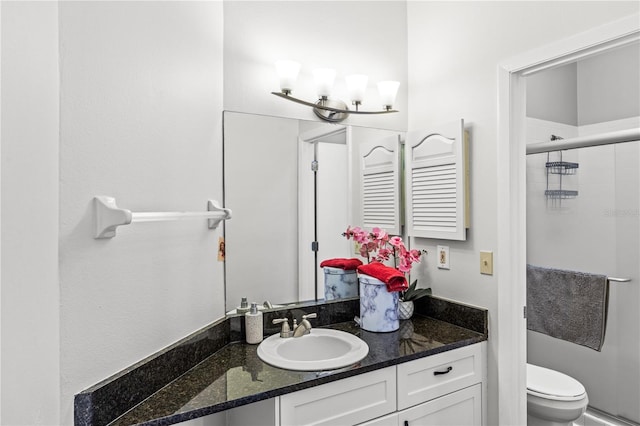 bathroom featuring vanity, toilet, and a shower with shower door