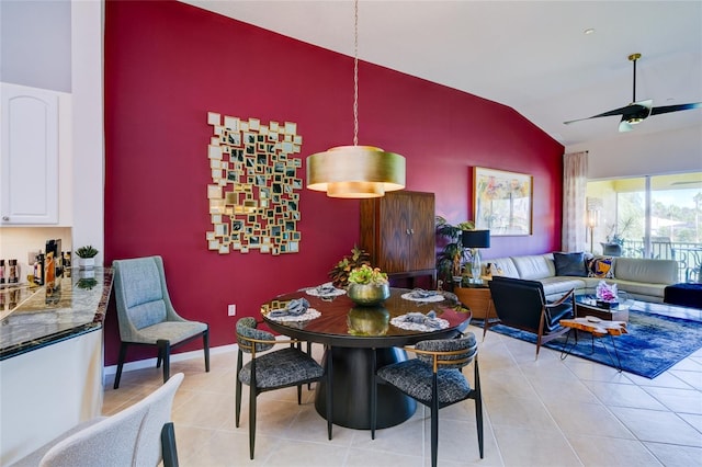 tiled dining area with ceiling fan and lofted ceiling