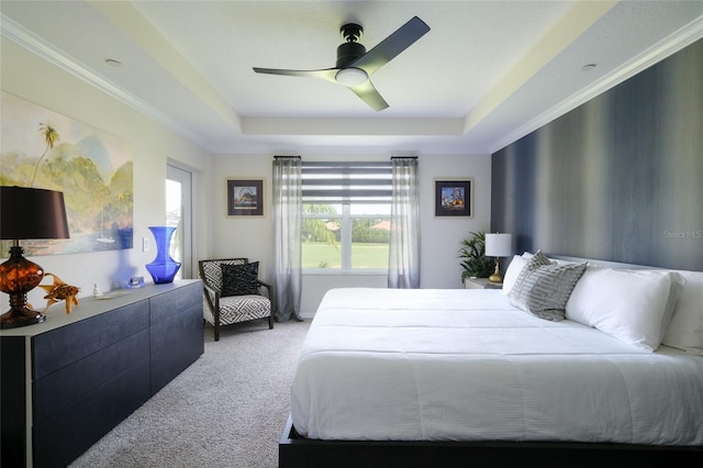 bedroom featuring ornamental molding, a tray ceiling, ceiling fan, and light colored carpet