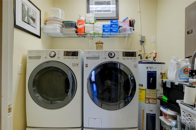 laundry area with water heater, electric panel, and washer and dryer