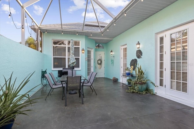 view of patio featuring glass enclosure