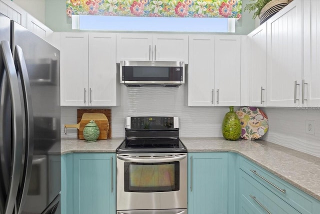 kitchen featuring appliances with stainless steel finishes, white cabinets, and plenty of natural light