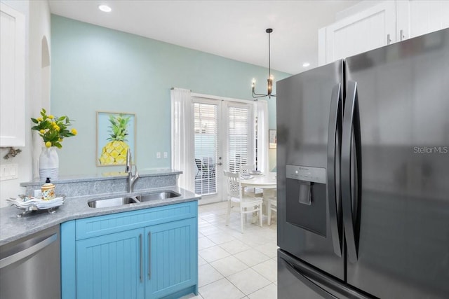 kitchen with sink, white cabinets, appliances with stainless steel finishes, light tile patterned floors, and blue cabinetry