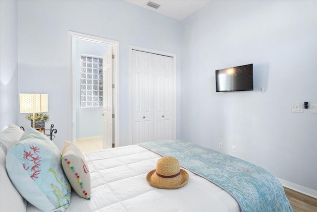 bedroom with a closet and hardwood / wood-style flooring