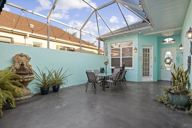 view of patio featuring glass enclosure