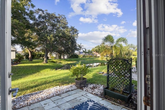 view of yard featuring a water view and a patio area