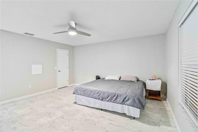 bedroom with a textured ceiling and ceiling fan