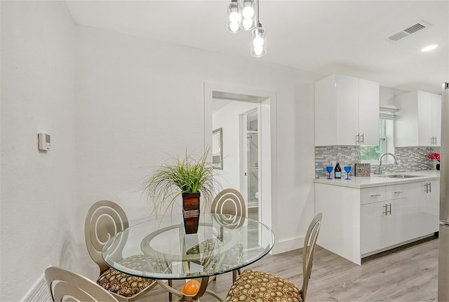 dining room with light hardwood / wood-style floors and sink