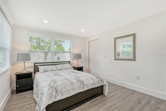 bedroom with light hardwood / wood-style flooring and a closet