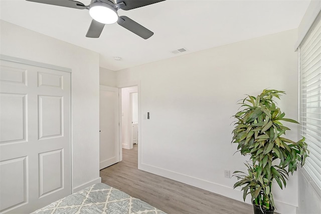 bedroom with light hardwood / wood-style flooring, a closet, and ceiling fan