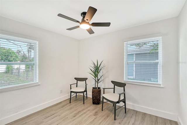 living area with light wood-type flooring, a healthy amount of sunlight, and ceiling fan