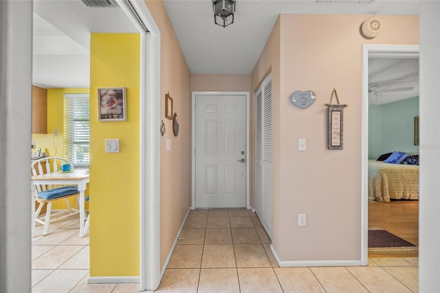 hall with light tile patterned floors and a textured ceiling