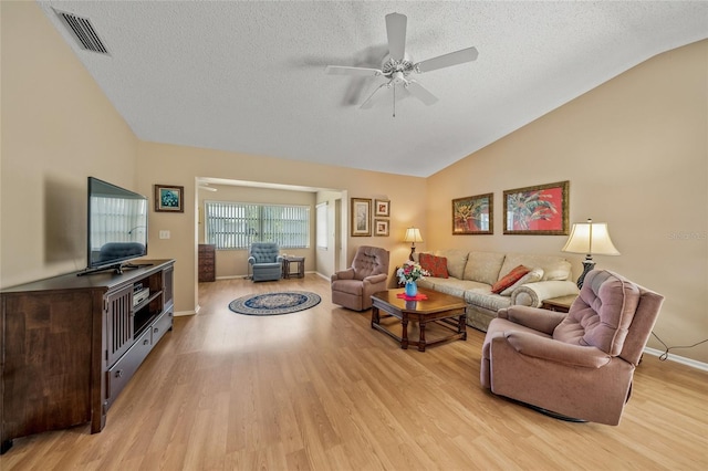 living room featuring light wood-type flooring, ceiling fan, vaulted ceiling, and a textured ceiling