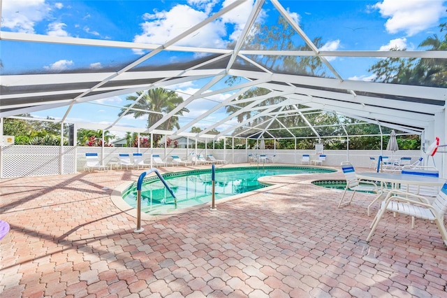 view of swimming pool with glass enclosure and a patio area