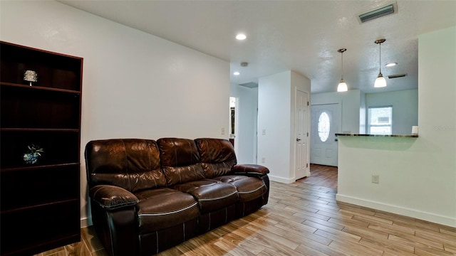 living room featuring a textured ceiling and light hardwood / wood-style floors