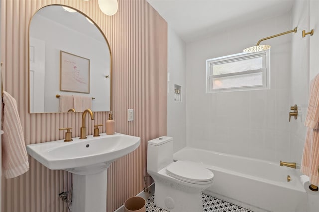 bathroom with tile patterned floors, tiled shower / bath, and toilet