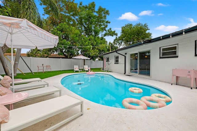 view of pool featuring a yard and a patio