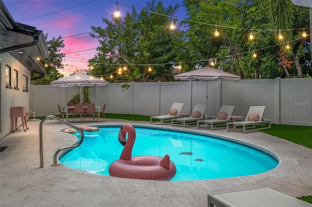 pool at dusk featuring a patio