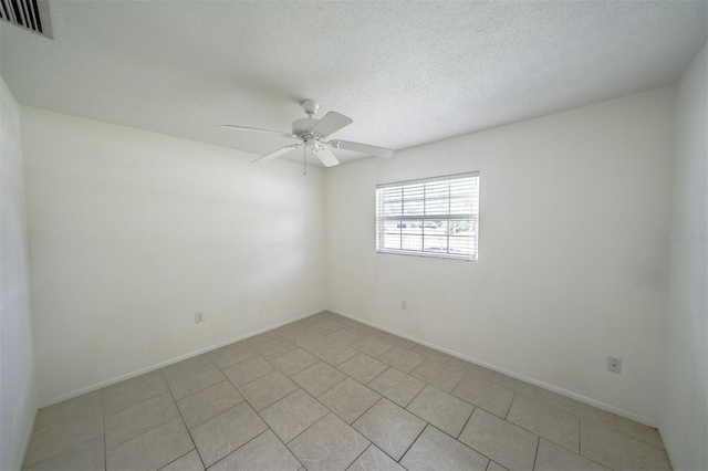 tiled spare room with ceiling fan and a textured ceiling