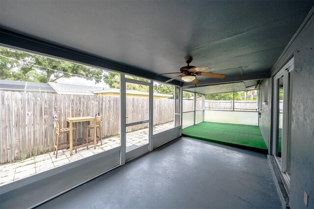 unfurnished sunroom featuring a wealth of natural light and ceiling fan