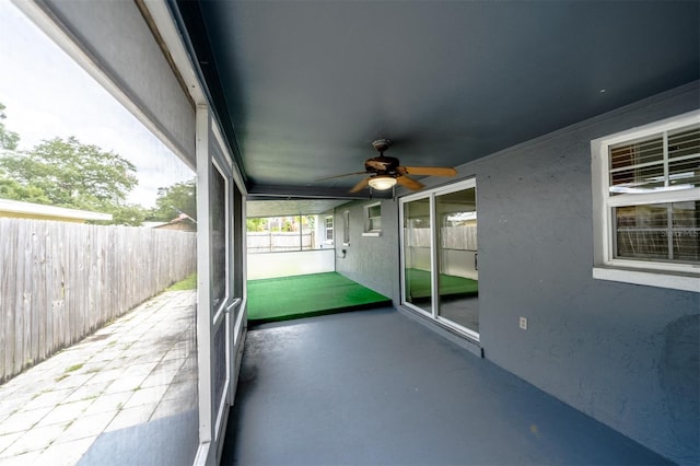 unfurnished sunroom with ceiling fan