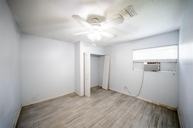 unfurnished bedroom with a textured ceiling, cooling unit, ceiling fan, and a closet