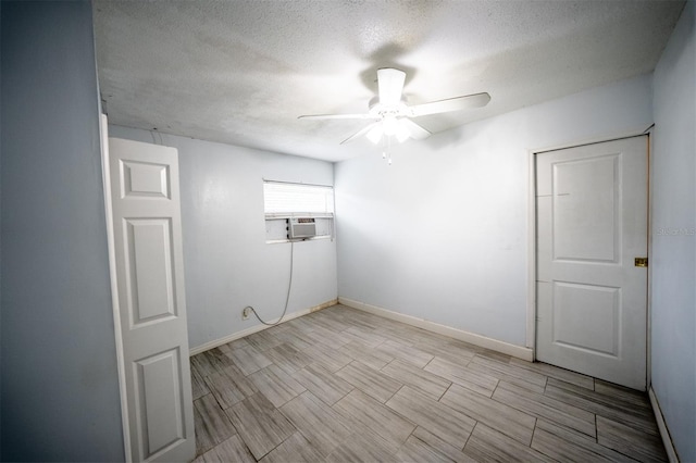 empty room featuring ceiling fan, cooling unit, and a textured ceiling