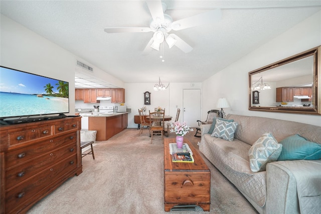 carpeted living room featuring a textured ceiling and ceiling fan with notable chandelier