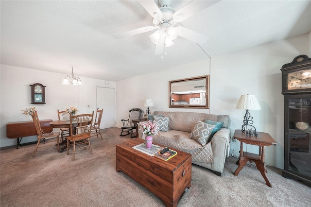 living room featuring a textured ceiling, ceiling fan with notable chandelier, and carpet