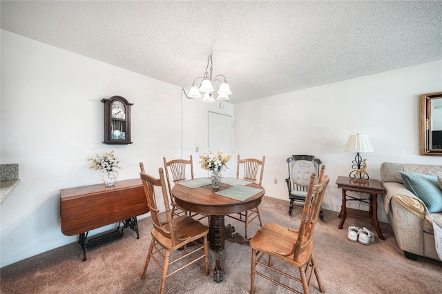 dining area featuring carpet, a chandelier, and a textured ceiling