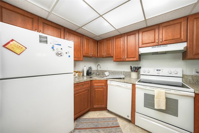 kitchen featuring white appliances, sink, a drop ceiling, and light stone counters