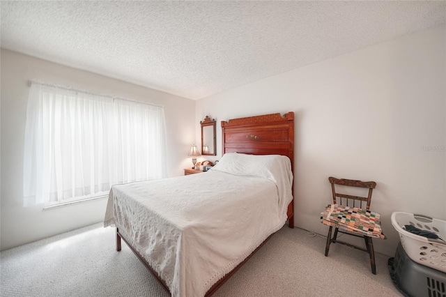 bedroom featuring light colored carpet and a textured ceiling