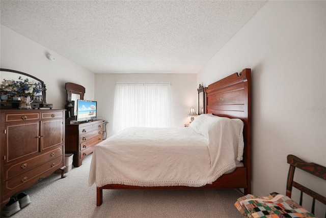 bedroom featuring a textured ceiling and light colored carpet