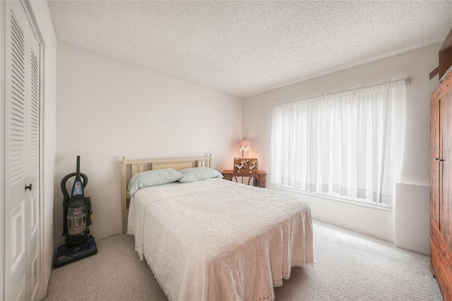 bedroom featuring a textured ceiling, light colored carpet, and a closet