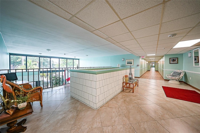 interior space featuring a drop ceiling and floor to ceiling windows