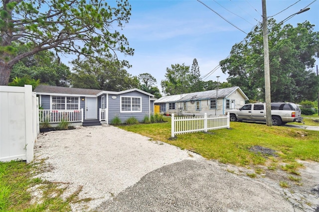 3419 19th St E, Bradenton, FL 34208 - view of front of house featuring gravel driveway, a front lawn, and fence