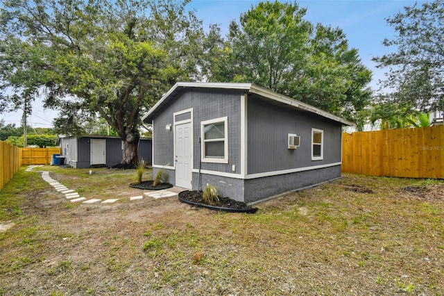 3419 19th St E, Bradenton, FL 34208 - view of property exterior featuring a wall mounted air conditioner, a fenced backyard, an outbuilding, and a shed