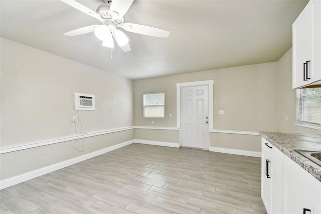 3419 19th St E, Bradenton, FL 34208 - interior space with baseboards, light wood-style floors, white cabinetry, ceiling fan, and light stone countertops