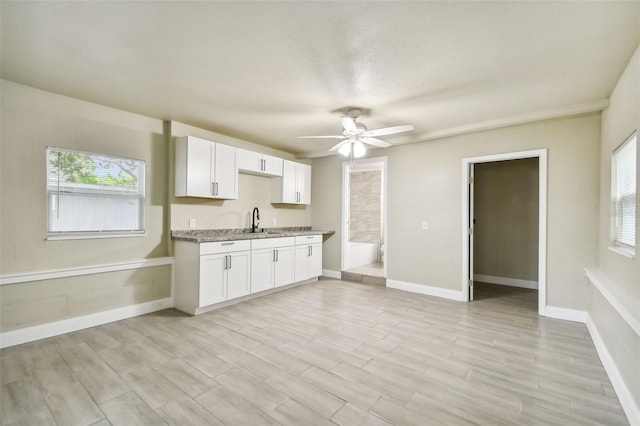 kitchen with ceiling fan, white cabinets, plenty of natural light, and light hardwood / wood-style floors