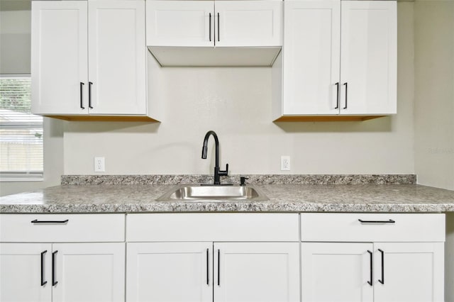 kitchen featuring white cabinetry and sink